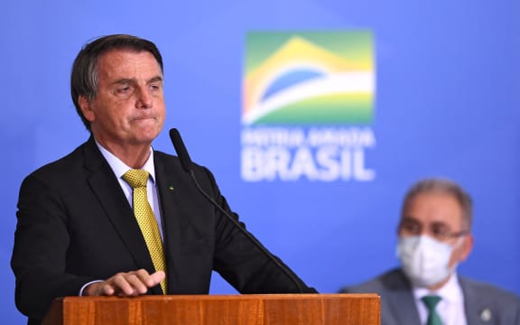 Brazilian President Jair Bolsonaro (L) speaks near Health Minister Marcelo Queiroga during the launching ceremony of a new registry of professional fishermen, at Planalto Palace in Brasilia on June 29, 2021.
