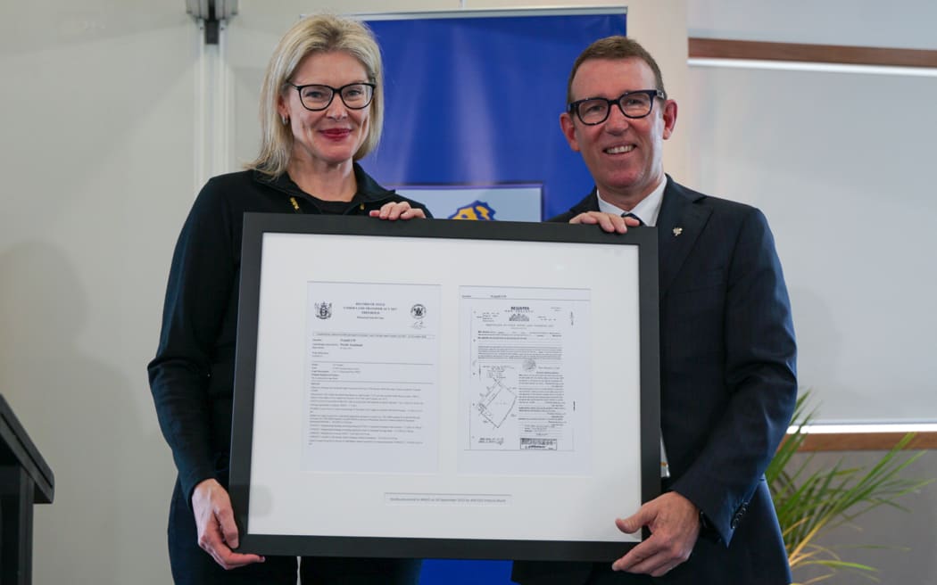 ASB chief executive Vittoria Shortt hands Mount Albert Grammar School headmaster Patrick Drumm the deed for the $150 million farmland which the school has leased since 1933.