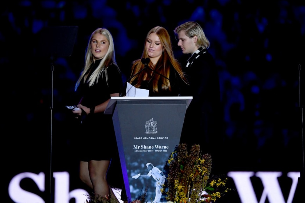 Shane Warne's children, Brooke Warne (L) Jackson Warne (R) and Summer Warne, take the stage during the state memorial service for the former Australian cricketer Shane Warne at Melbourne Cricket Ground (MCG) in Melbourne on March 30, 2022.