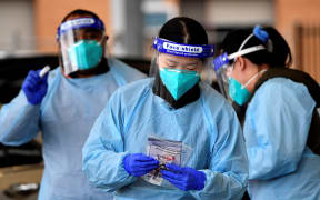 Health workers collect swab samples from residents at a Covid-19 drive-through testing clinic in Sydney's Fairfield suburb on July 14, 2021.