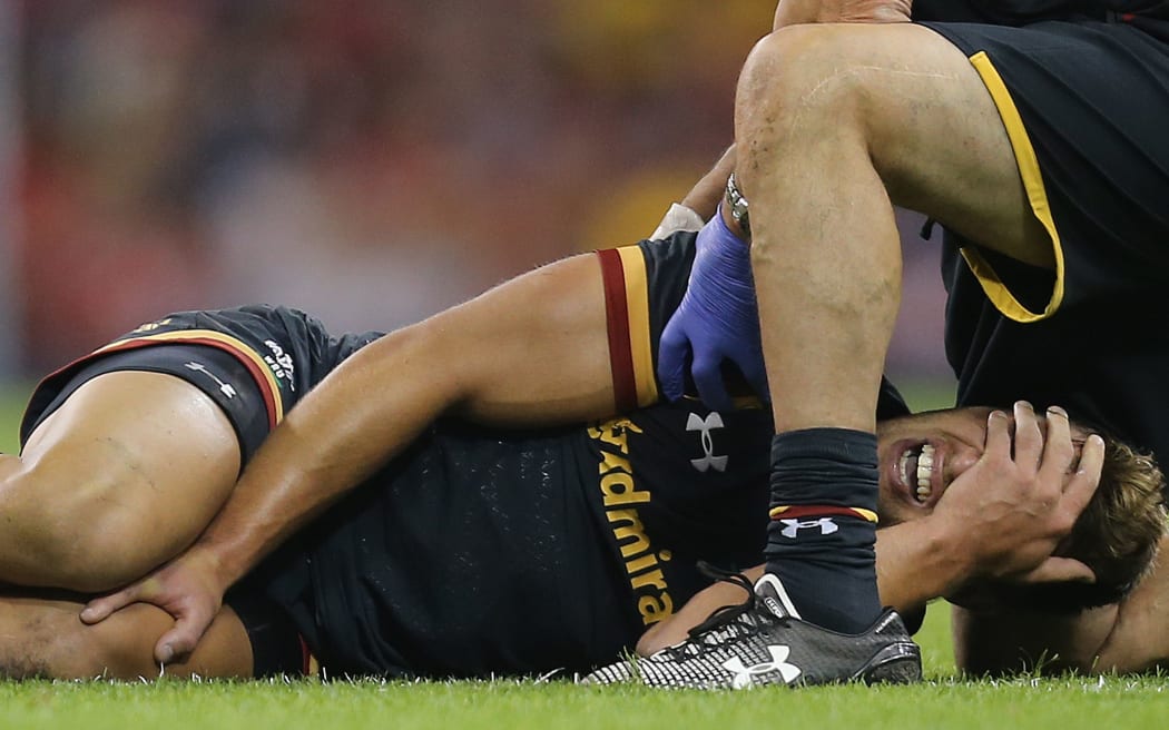 Rhys Webb of Wales shows the pain as he receives treatment for a leg injury