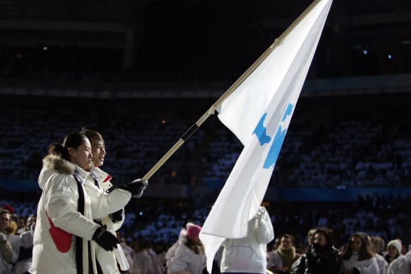 South Korea speed skater Bora Lee joined with Democratic People's Republic of Korea's figure skater Han Jong-In enter the Stadio Olimpico as they lead their delegation during the opening ceremony of the 2006 Winter Olympics.