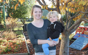 A photo of Brooke Gray and her son, Max, in the creche garden at Karanga Mai Young Parents College