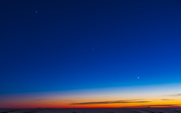 December 17, 2021 - The line-up of three evening planets in the southwest twilight sky, with Jupiter at top left, Venus at bottom right, and dimmer Saturn in the middle, all defining the line of the ecliptic in the cold winter sky this night. The stars of Capricornus are at centre. (Photo by Alan Dyer / StockTrek Images via AFP)