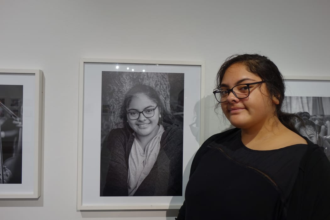 Willow Tuliakiono next to her photo which is part of the Virtuoso Strings photo exhibition.