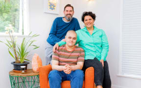 Otis Hill sitting with dad Tyson and mum Rachel Hill.