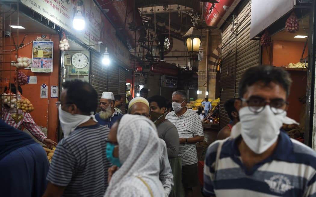 People shop in a local market in Mumbai on 24 March 2020.