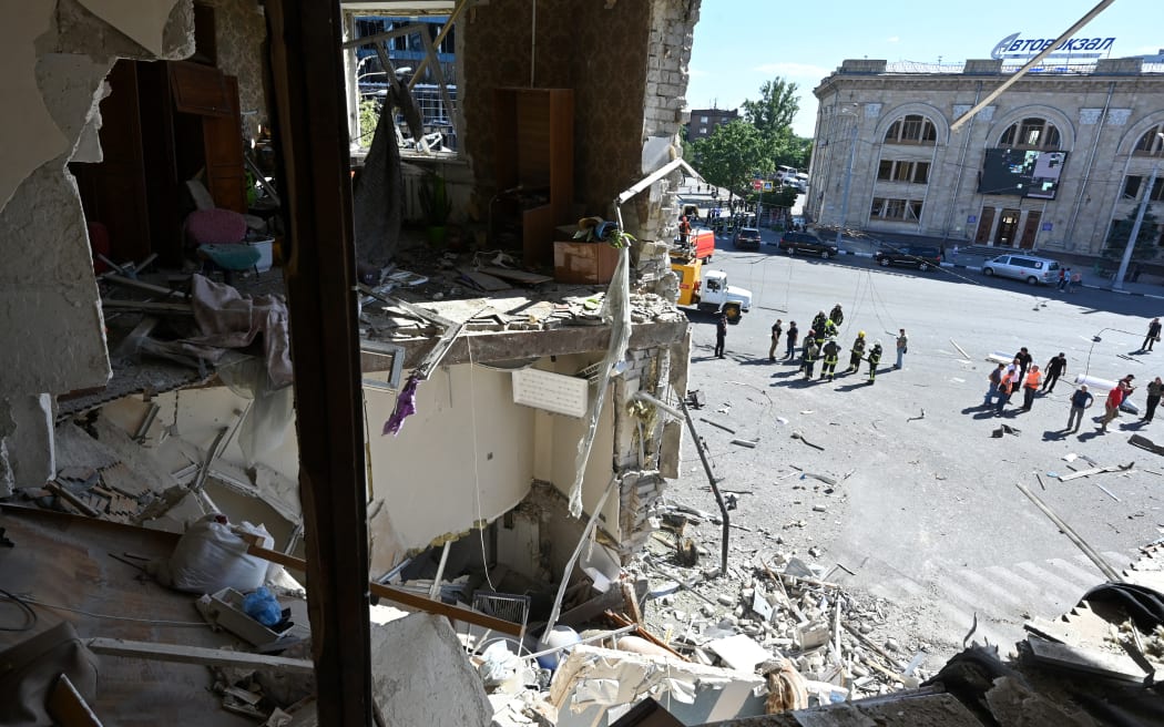 Rescuers work at the site of a destroyed apartment building following an aerial bomb in the centre of Kharkiv, on 22 June, 2024.