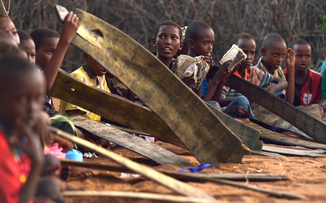 Young boys hold their slates as they attend morning madrassa or Islamic religious classes at Hagadera sector of the Dadaab refugee camp, north of the Kenyan capital Nairobi.