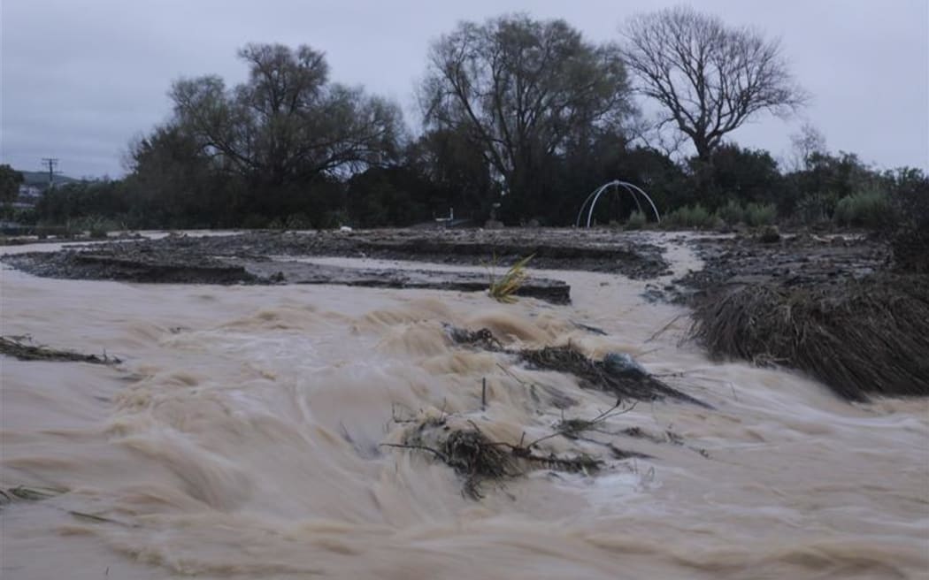 Raging water flows wash away debris and top soil from land in Nelson.