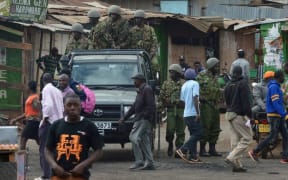 Kenyan riot police officers patrol a neighbourhood in Nairobi following riots.