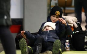 Evacuees of Ukraine sit at Krakow station in Krakow, southern Poland on March 6, 2022. Lots of Ukrainians are heading to Poland to escape the war. Russian President Vladimir Putin
