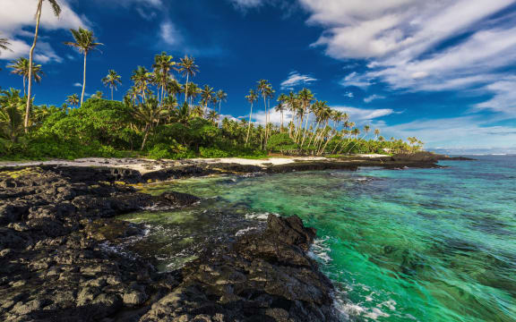 Beach with coral reef and black volcanic rocks on south side of Upolu, Samoa Islands