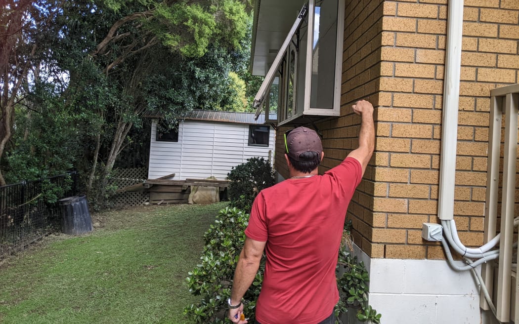 Tom White shows the level the water reached during the flood.