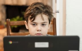 A young boy views content on a digital device.
