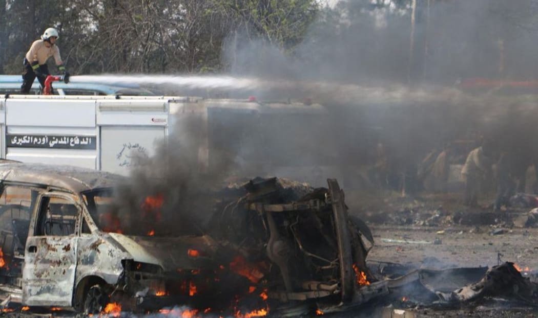 Civil team members try to extinguish a fire after the blast.