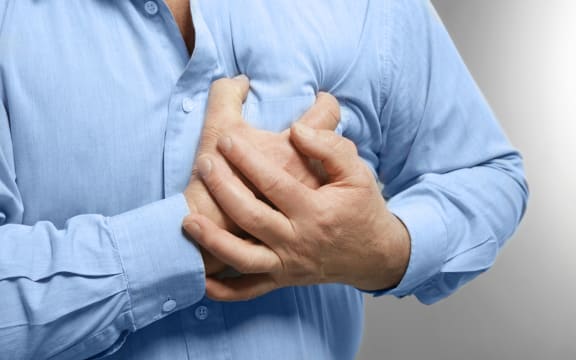 Elderly man holding hands on chest suffering from heart attack, closeup