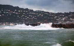 Waves crash against a sea wall near the end of Wellington Airport