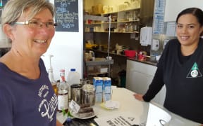 Robin Mead orders a hot chocolate from Charlanne Te Awhe. Kapu Kōrero