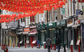 LONDON, UNITED KINGDOM - APRIL 16: People walk in an almost-empty street in Chinatown, London, United Kingdom on April 16, 2020,