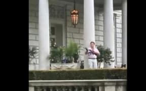 This screen grab taken from a video shows Mark McCloskey, 63, and his 61-year-old wife, Patricia, standing outside their home and holding guns including a semi-automatic rifle at Black Lives Matter protesters.