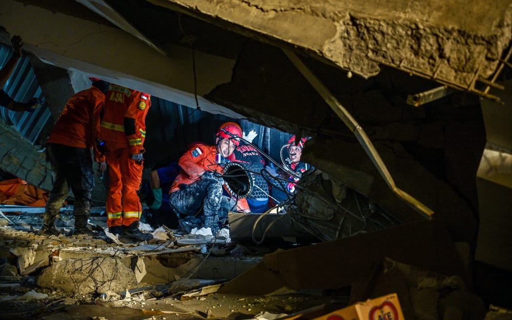 Rescue personnel search for survivors after a building collapsed at an Islamic boarding school in Sidoarjo, East Java province on September 29, 2025, injuring a number of students and trapping several others under the rubble. (Photo by Juni KRISWANTO / AFP)