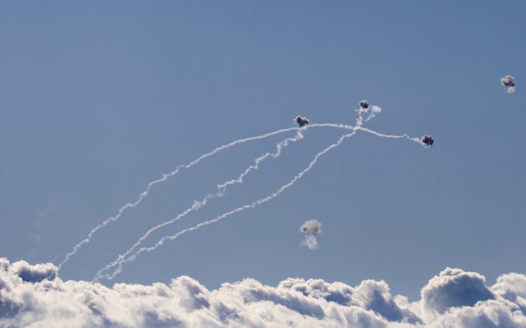 Rockets fired from southern Lebanon are intercepted by Israel's Iron Dome air defence system over the Upper Galilee region in northern Israel on September 18, 2024. (Photo by Jalaa MAREY / AFP)