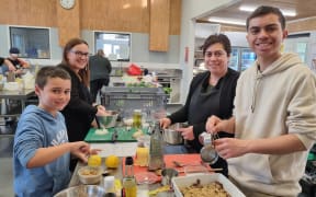 The Burnard family - clockwise from left foreground, Riley, 9, Helena Simpson (Barbara's sister), Barbara Burnard and Blake, 16. Riley and Barbara squeeze lemons for the pudding while Caleb prepares the sauce.