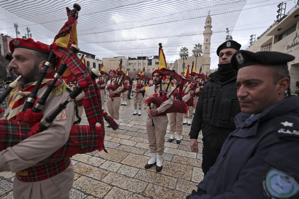 In Bethlehem Palestinian scouts parade outside the Church of the Nativity, revered as the site of Jesus Christ's birth, with security forces standing guard during Christmas celebrations in the Israeli-occupied West Bank.