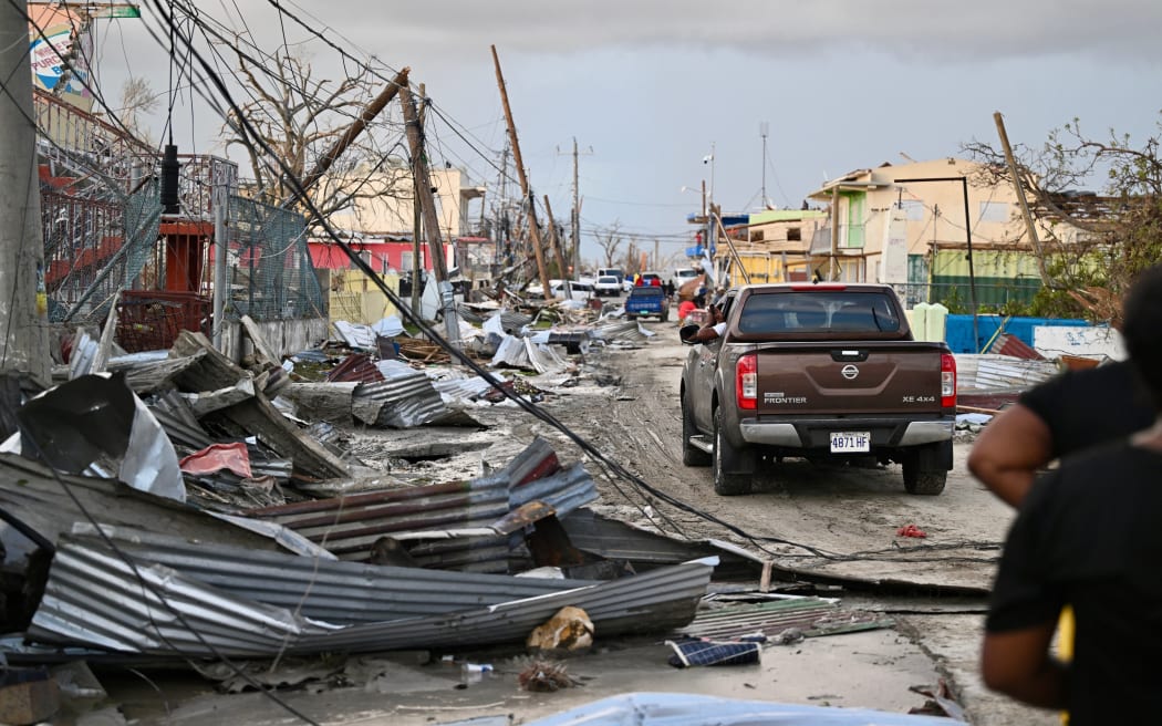 A car drives through the a destroyed neighbourhood following the passage of Hurricane Melissa, in Black River, Jamaica.