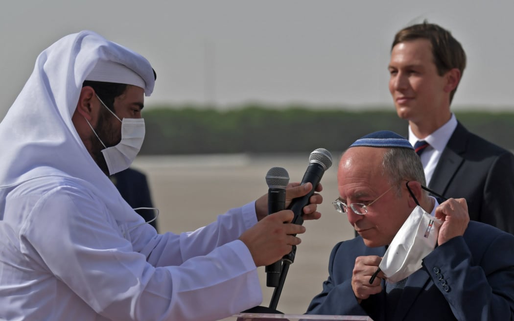 The Head of Israel's National Security Council, Meir Ben-Shabbat, puts on a facemask next to US Presidential Adviser Jared Kushner (R) at the tarmac of Abu Dhabi airport following the arrival of the first-ever commercial flight from Israel to the UAE, on August 31, 2020.