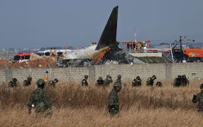 South Korean soldiers search for missing passengers near the wreckage of a Jeju Air Boeing 737-800 series aircraft after the plane crashed and burst into flames at Muan International Airport in South Jeolla Province, some 288 kilometres southwest of Seoul on December 29, 2024. - A Jeju Air plane carrying 181 people from Bangkok to South Korea crashed on arrival December 29, colliding with a barrier and bursting into flames, with only two survivors rescued so far and 120 confirmed dead. (Photo by JUNG YEON-JE / AFP)