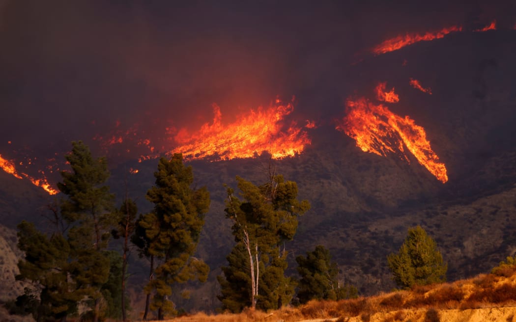 The smoke and flames of the Hughes Fire are seen near Castaic Lake, California, on Wednesday.