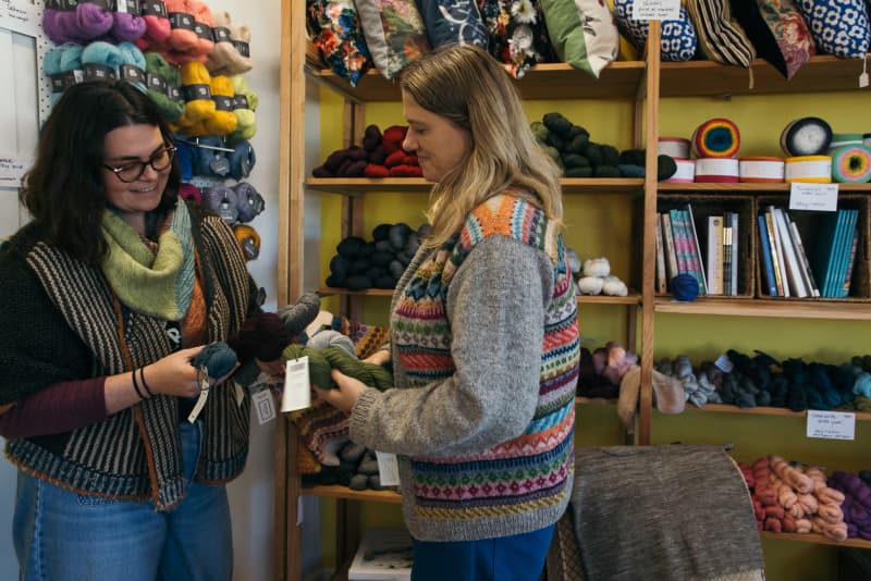 Katie Minett and Tash Barneveld inside the Holland Road Yarn Company look at their yarn products.