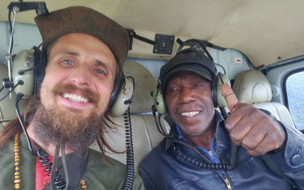 Phillip Mehrtens, left, with former acting Bupati of Nduga regency, Edison Gwijangge, in the helicopter on his release from captivity.
