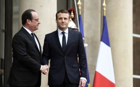 Emmanuel Macron (right) is welcomed at the Elysee presidential Palace by his predecessor François Hollande.