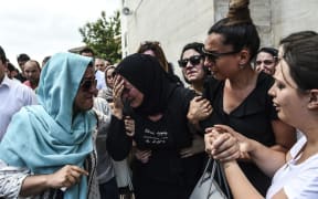 The daughter of a man who was killed in the airport attack reacts as her father's coffin is carried nearby during his funeral ceremony.