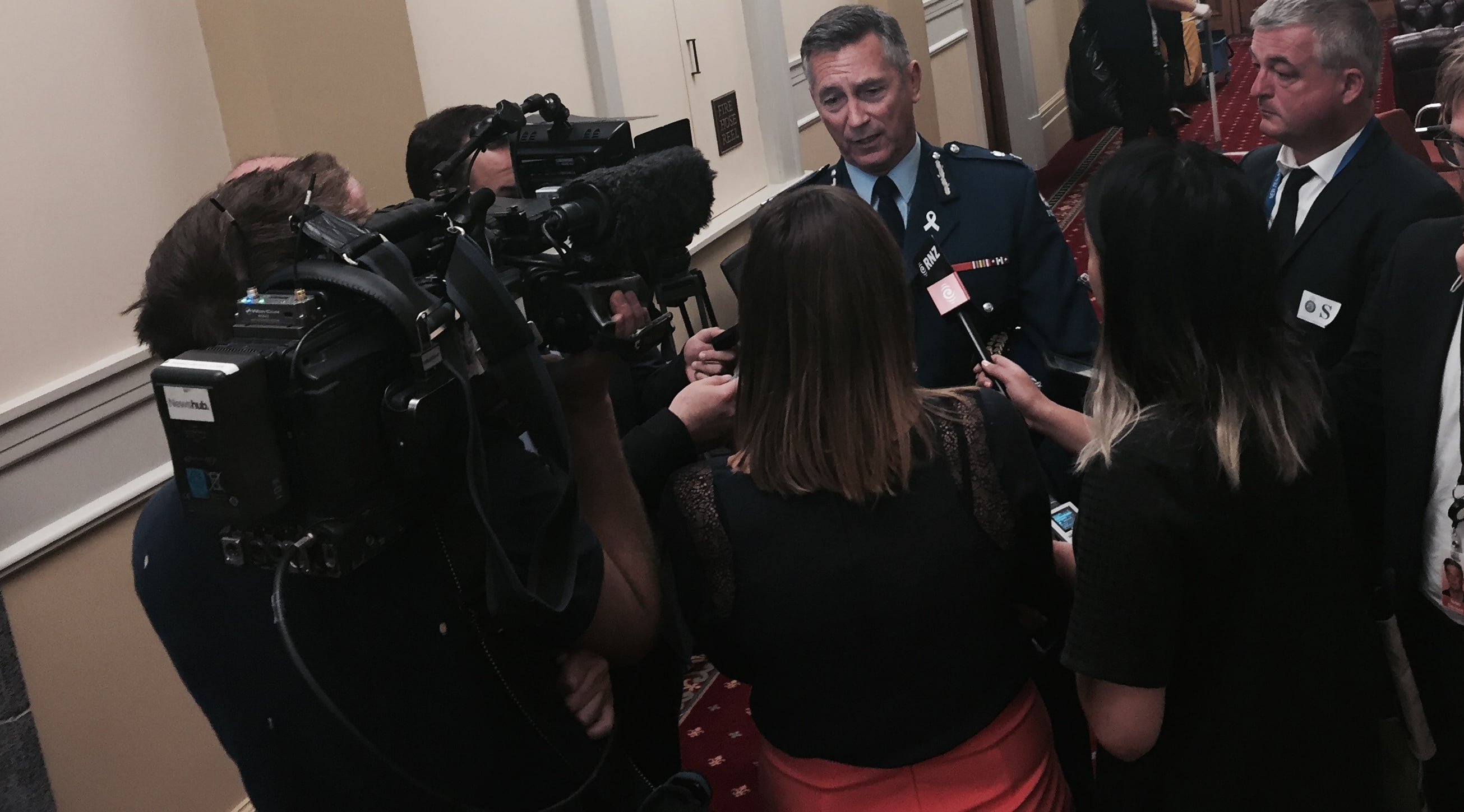 Police Commissioner Mike Bush is questioned by journalists outside a select committee room following the annual review of New Zealand Police.