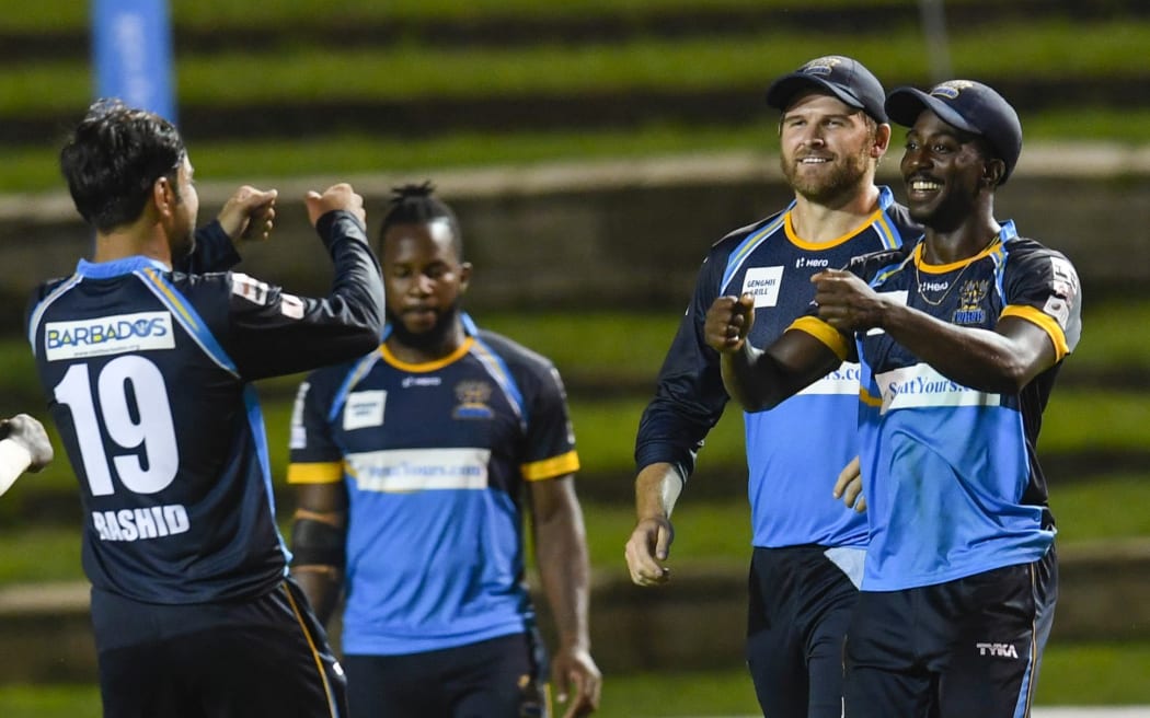 Hayden Walsh Jr. (R), Corey Anderson (2R) and Barbados Tridents celebrate a wicket. CPL, 2020.