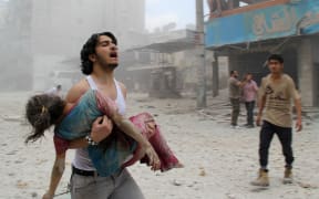 A man carries a girl injured in a reported barrel-bomb attack by government forces  in Kallaseh district in the northern city of Aleppo.
