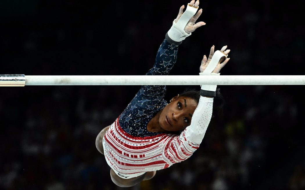 US' Simone Biles practises in the uneven bars event of the artistic gymnastics women's team final during the Paris 2024 Olympic Games at the Bercy Arena in Paris, on July 30, 2024. (Photo by Loic VENANCE / AFP)