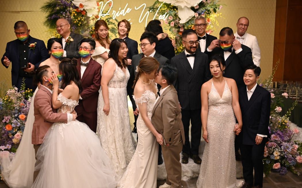 10 LGBTQ couples celebrate “getting married in a mass wedding” ceremony in Hong Kong on June 25, 2024, performed by a pastor online from the state of Utah in the USA, as same-sex marriages or civil unions are not recognised in Hong Kong. (Photo by Peter PARKS / AFP)