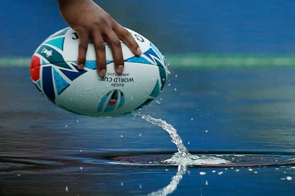 A rugby ball is seen in a puddle of rainwater during South Africa's Captain's Run session at the International Stadium Yokohama in Yokohama on October 25, 2019, ahead of the Japan 2019 Rugby World Cup semi-final match against Wales. (Photo by Odd Andersen / AFP)