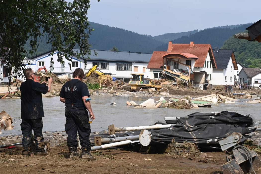 A worker takes a picture of a destroyed area in Insul near Bad Neuenahr-Ahrweiler, western Germany.