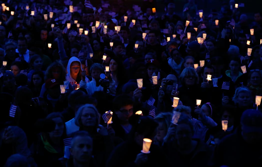 People gather with candles during a vigil for eight-year-old Martin Richard, from Dorchester, who was killed by an explosion near the finish line of the Boston Marathon in 2013.