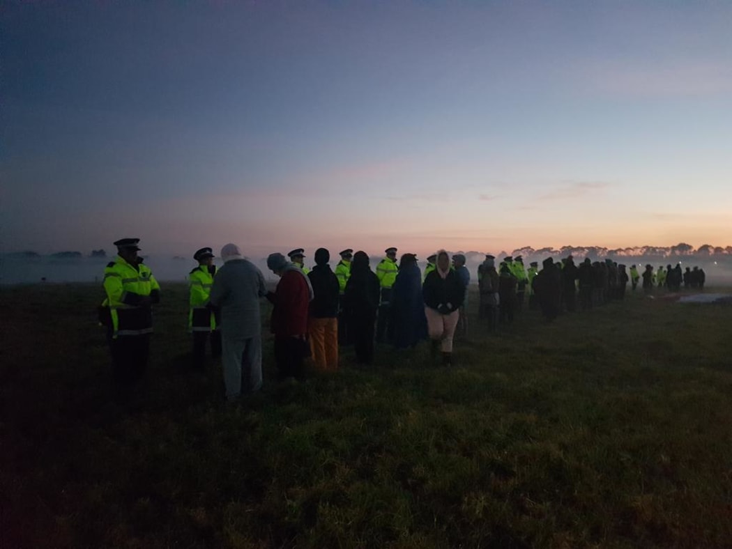 Police and protesters at dawn at Ihumātao in Auckland on 25 July 2019.