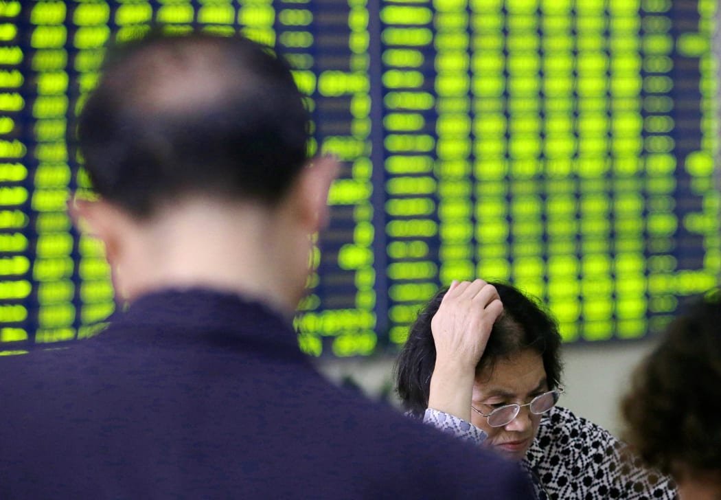 Concerned Chinese investors look at prices of shares (green for price falling) at a stock brokerage house in Nantong city, east China's Jiangsu province