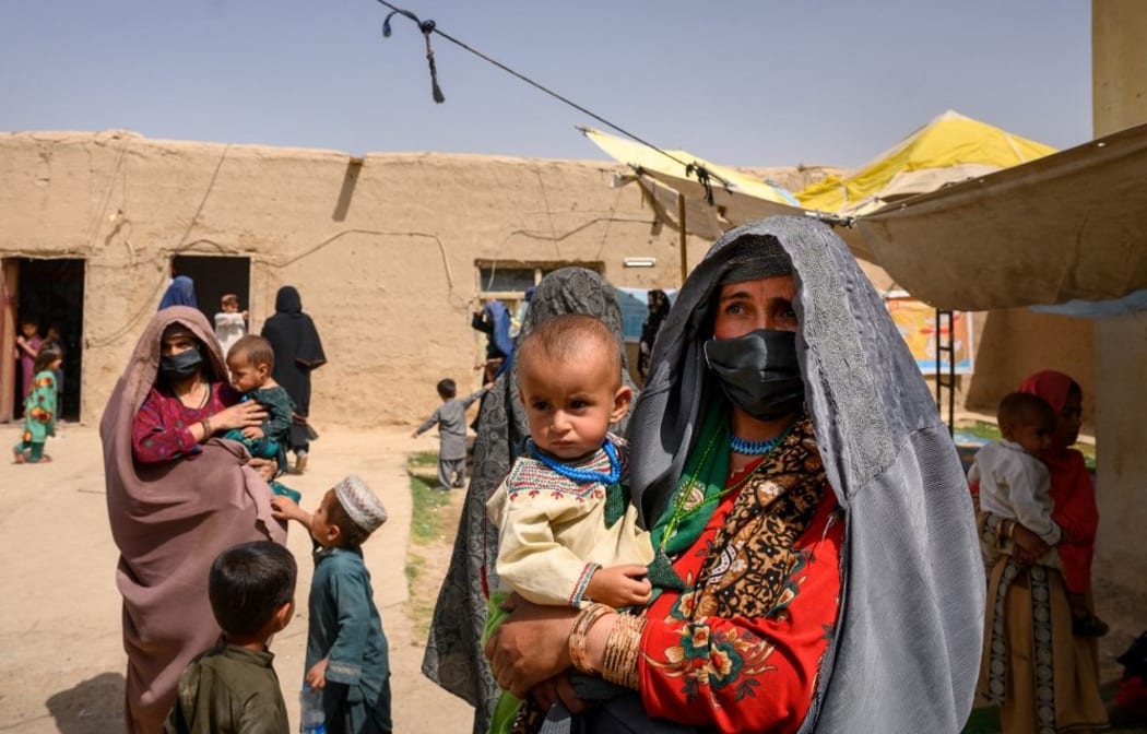 In this picture taken on March 28, 2021, Farzana, who fled her village in Helmand province when it was taken over by the Taliban, waits to see a doctor at a mobile clinic for women and children set up at the residence of a local elder in Yarmuhamad village, near Lashkar Gah in Helmand province.