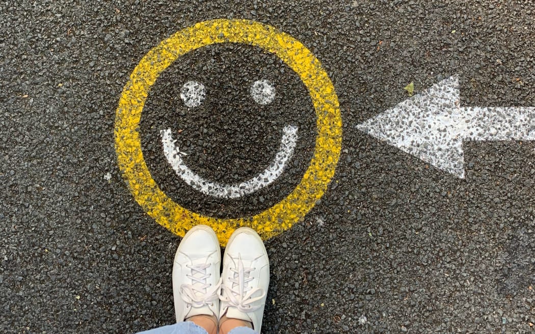 Smiley face sign on pavement denoting happiness