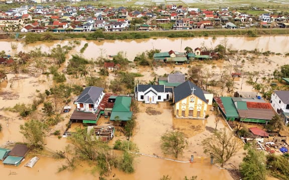 An aerial photo shows flood waters surrounding homes after typhoon Bualoi passed over Lam Thanh commune in Nghe An province on September 30, 2025. A severe storm that ripped roofs off homes has killed dozens of people across Vietnam and the Philippines, officials from both countries said on September 29, as weakened Bualoi crossed into neighbouring Laos. (Photo by Phan Duy / AFP)